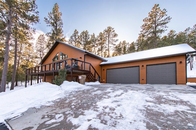 chalet / cabin with a garage, a deck, and stairway