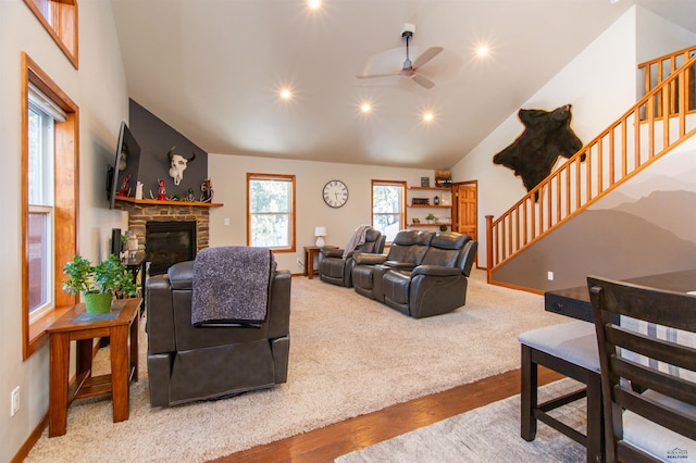 living room with stairs, a stone fireplace, a ceiling fan, and baseboards