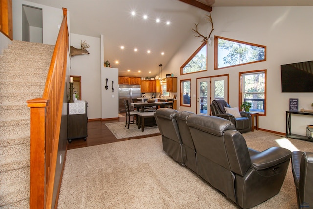 living area featuring stairs, beam ceiling, baseboards, and high vaulted ceiling