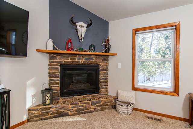 details with visible vents, baseboards, carpet, and a fireplace