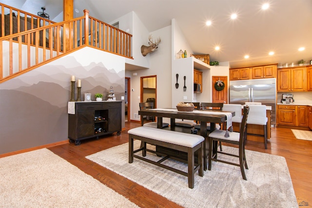 dining room featuring recessed lighting, baseboards, light wood finished floors, and high vaulted ceiling