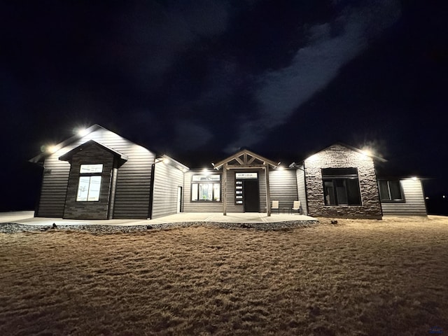 view of front facade with stone siding and a patio