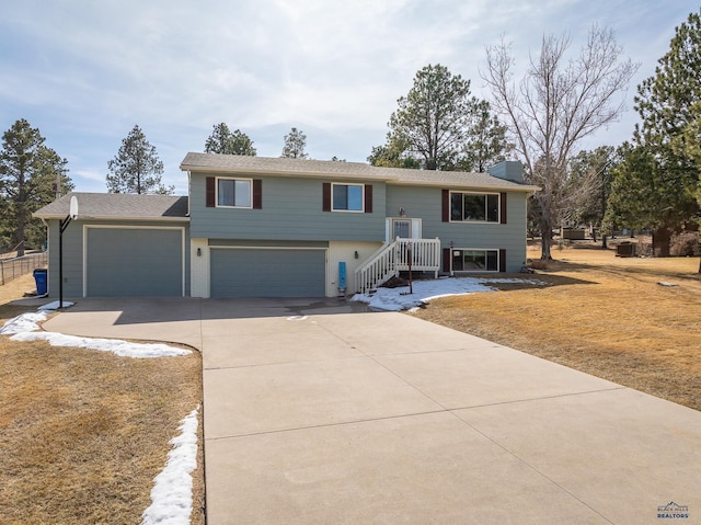 bi-level home with concrete driveway, brick siding, and a chimney