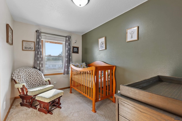 bedroom with a textured ceiling, baseboards, carpet, and a textured wall