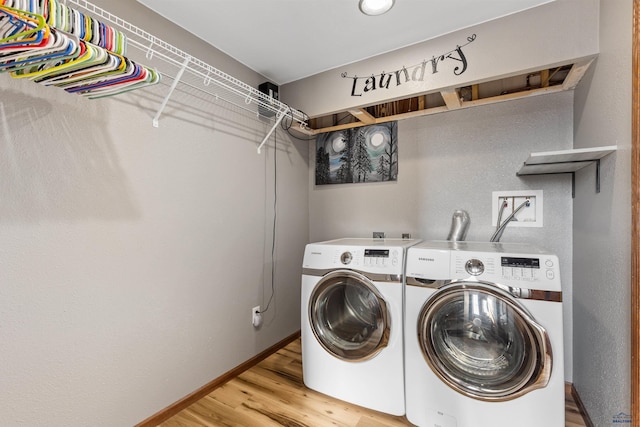 laundry room with laundry area, washer and dryer, light wood-style flooring, and baseboards