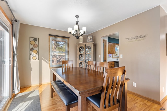 dining space with a notable chandelier, light wood-style floors, and baseboards