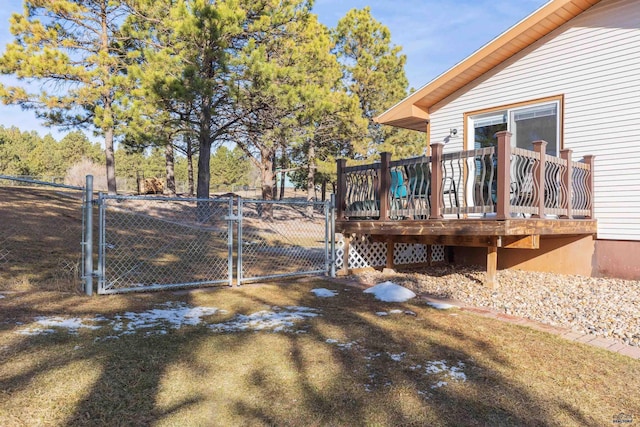 view of yard with a wooden deck, fence, and a gate