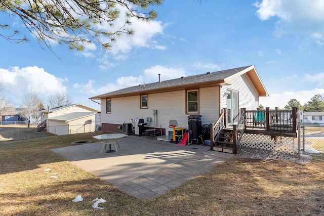 back of house featuring a patio area, a lawn, a deck, and fence