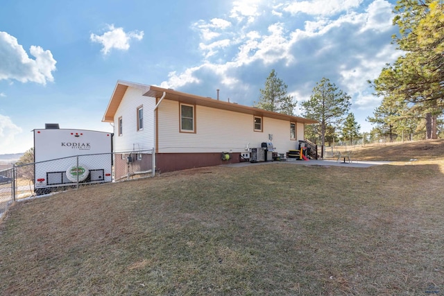 view of home's exterior with a yard, cooling unit, and fence