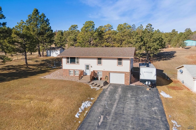 split foyer home with aphalt driveway, an attached garage, and brick siding