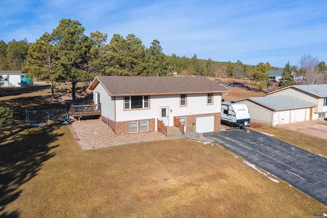 split foyer home with aphalt driveway, brick siding, and an attached garage