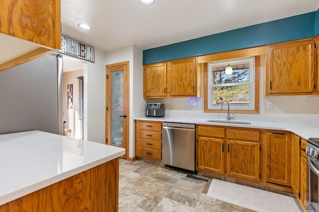 kitchen with a sink, light countertops, brown cabinets, and stainless steel appliances