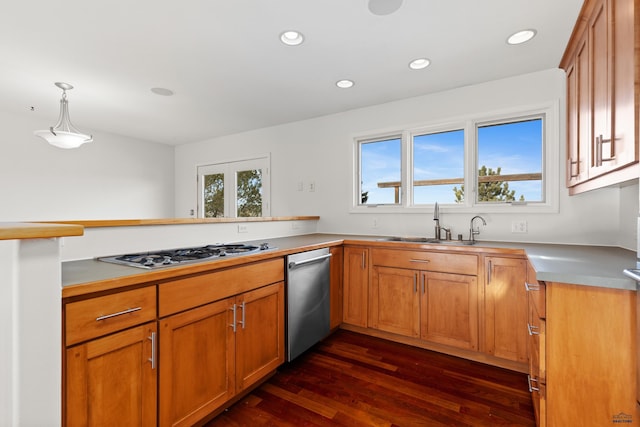 kitchen featuring pendant lighting, recessed lighting, appliances with stainless steel finishes, dark wood-style floors, and a sink