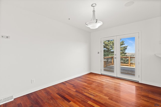 unfurnished dining area with visible vents, baseboards, and wood finished floors