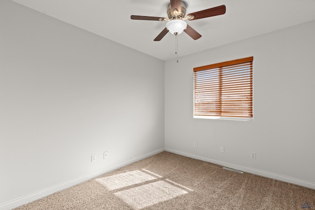 carpeted empty room with visible vents, ceiling fan, and baseboards