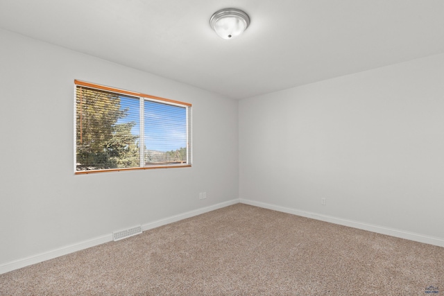 unfurnished room with visible vents, baseboards, and carpet floors