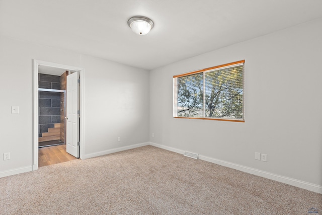 unfurnished bedroom with visible vents, baseboards, and light colored carpet