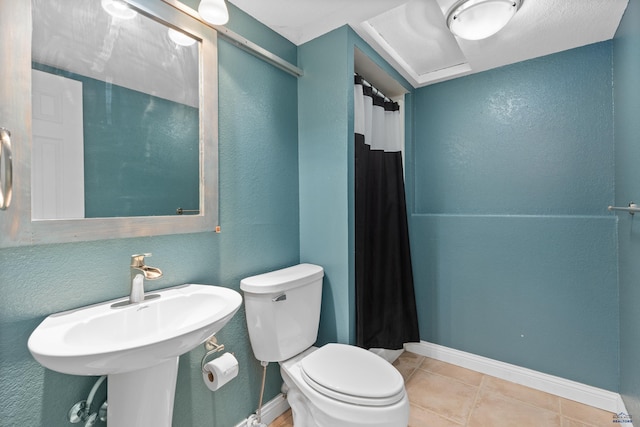 full bath with toilet, a sink, a shower with shower curtain, tile patterned flooring, and baseboards