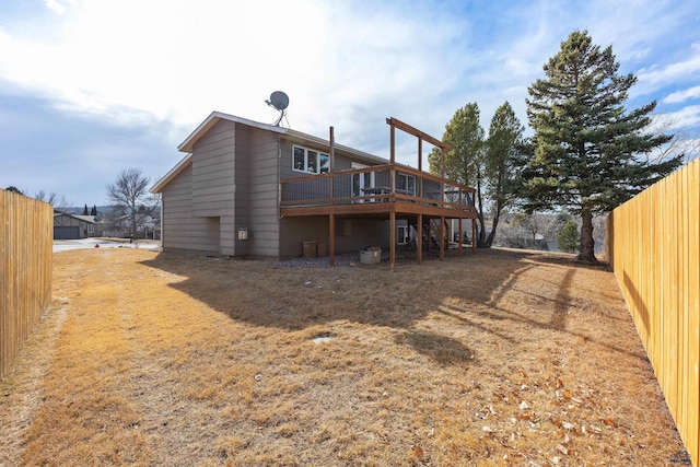 rear view of house featuring a deck and fence