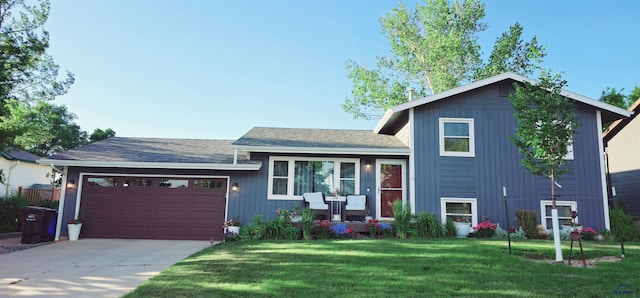 tri-level home with a garage, concrete driveway, and a front yard