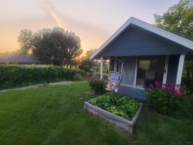 back of house at dusk with a lawn