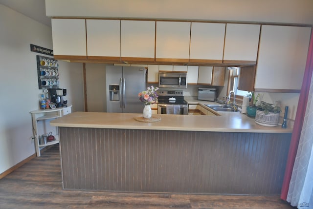 kitchen with a sink, light countertops, a peninsula, and stainless steel appliances