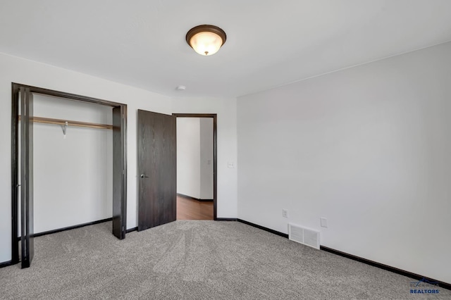 unfurnished bedroom featuring visible vents, baseboards, a closet, and carpet flooring