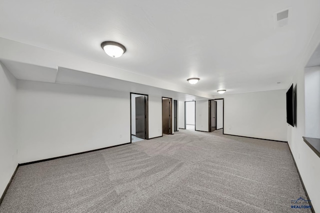 unfurnished room with baseboards, visible vents, and light carpet