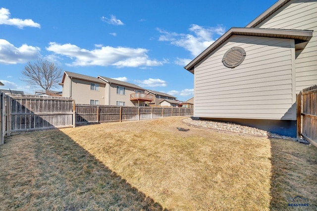 view of yard featuring a fenced backyard and a residential view