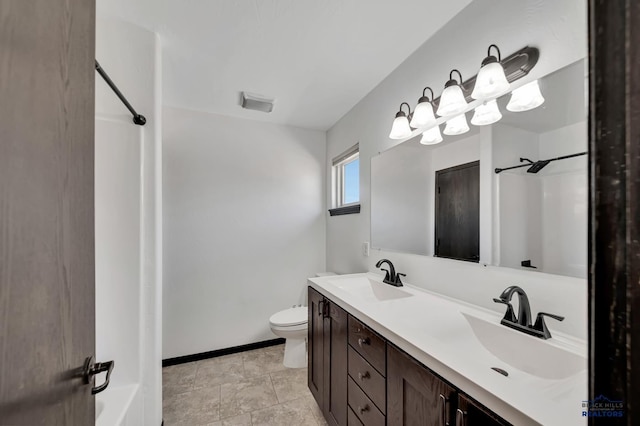 full bath featuring a sink, baseboards, toilet, and double vanity