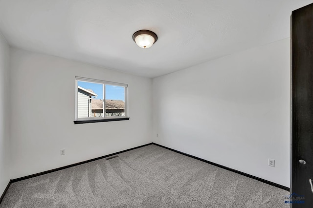 empty room featuring visible vents, baseboards, and carpet