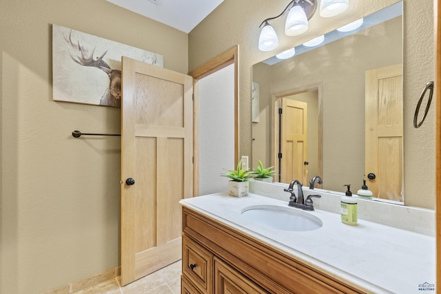 bathroom featuring vanity, a textured wall, and tile patterned flooring