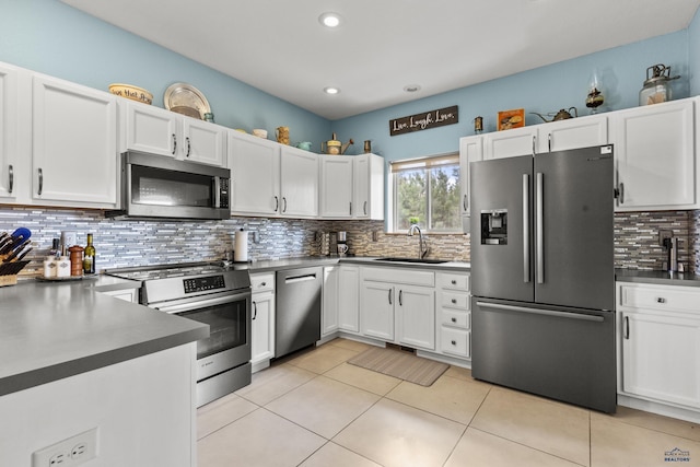 kitchen featuring a sink, dark countertops, appliances with stainless steel finishes, and white cabinets