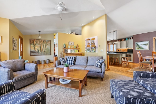 living room with wine cooler, lofted ceiling, light wood-style flooring, and recessed lighting