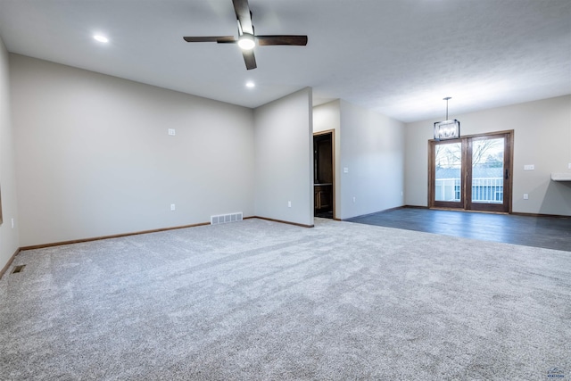 carpeted empty room featuring recessed lighting, visible vents, baseboards, and ceiling fan with notable chandelier