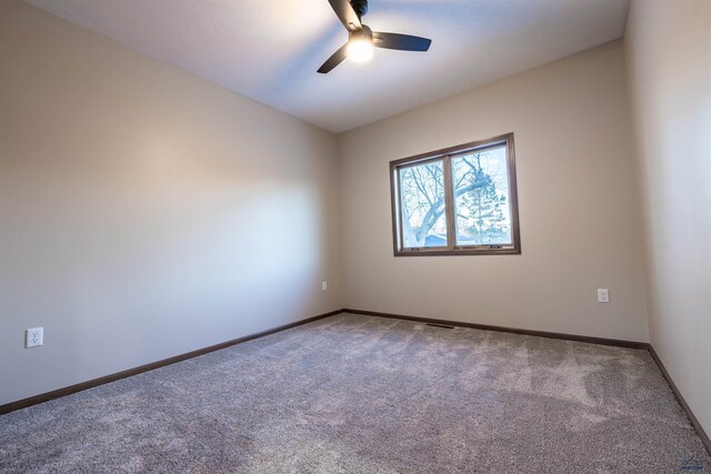 carpeted empty room with ceiling fan and baseboards