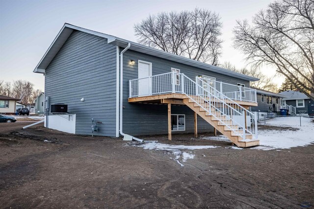 rear view of property with stairway, central AC unit, and a wooden deck