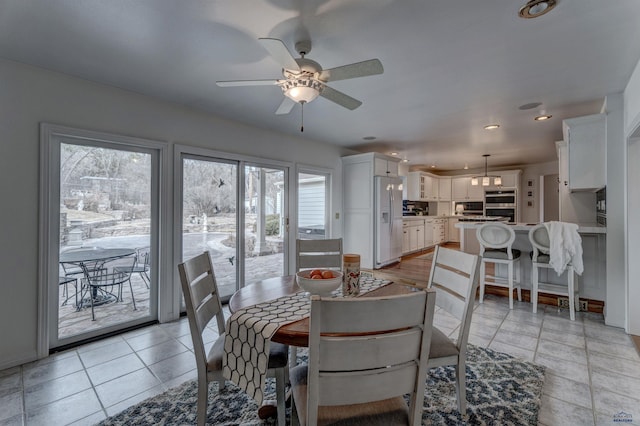 dining space with light tile patterned floors, a ceiling fan, recessed lighting, and baseboards