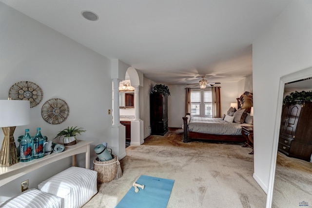 bedroom featuring carpet flooring, baseboards, arched walkways, and ornate columns