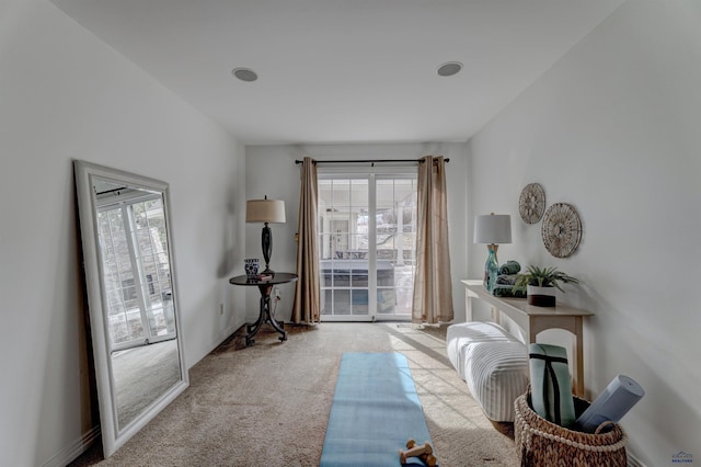 sitting room featuring baseboards, carpet floors, and a healthy amount of sunlight