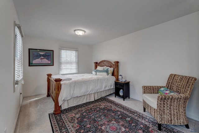 bedroom with baseboards and light colored carpet