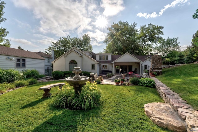 rear view of house with a patio and a lawn