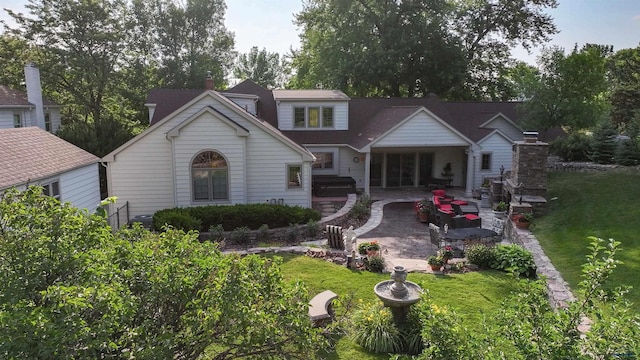 back of property featuring a patio area, a chimney, and a yard