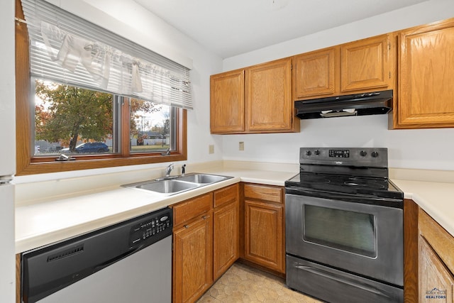 kitchen with brown cabinetry, a sink, stainless steel appliances, light countertops, and under cabinet range hood