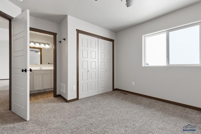 unfurnished bedroom featuring baseboards, visible vents, carpet floors, a closet, and a textured ceiling