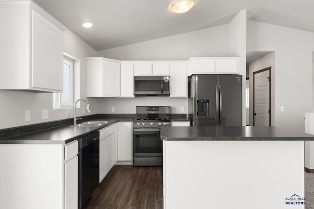 kitchen featuring dark countertops, white cabinets, appliances with stainless steel finishes, and a sink