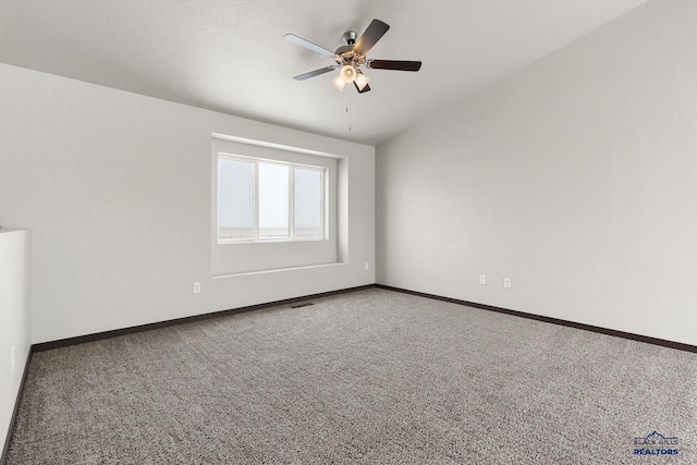 empty room with visible vents, ceiling fan, baseboards, lofted ceiling, and carpet floors