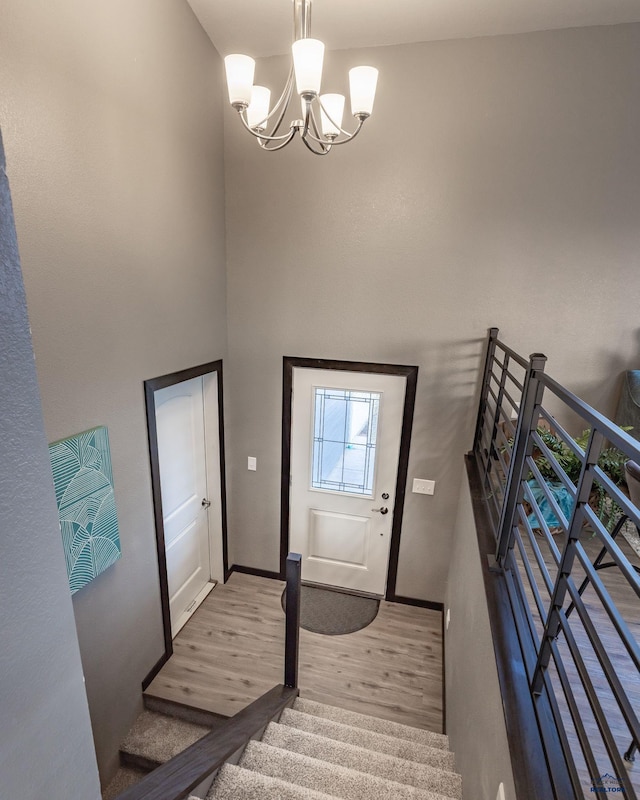 6748 Receda St, Rapid City, SD 57703 - foyer entrance featuring stairway, wood finished floors, baseboards, a high ceiling, and a notable chandelier
