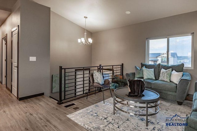 6748 Receda St, Rapid City, SD 57703 - living area with visible vents, lofted ceiling, an inviting chandelier, and light wood-style flooring