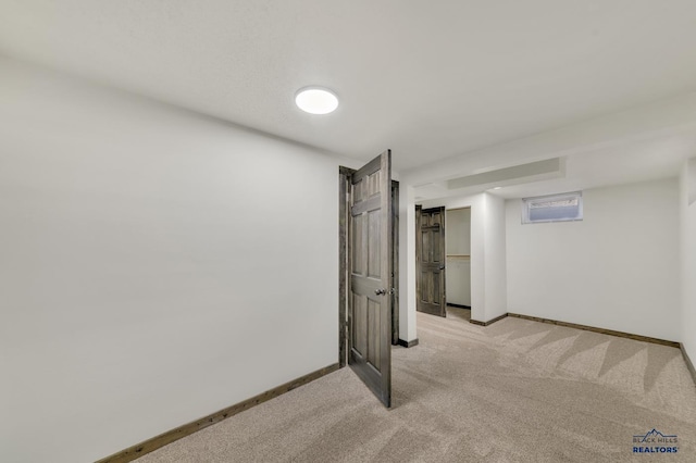 finished below grade area with baseboards and light colored carpet